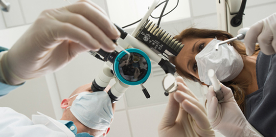 Doctor and dental technician examining a specimen under a microscope